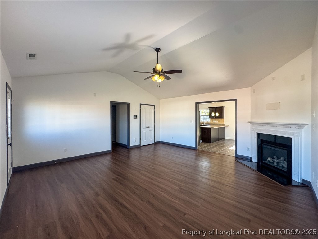 142 Crestwood Lane Raeford, NC 28376 - Photo 7 of 30 an empty room with wooden floor fireplace and windows