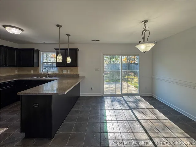 a kitchen with granite countertop a stove a sink and a window