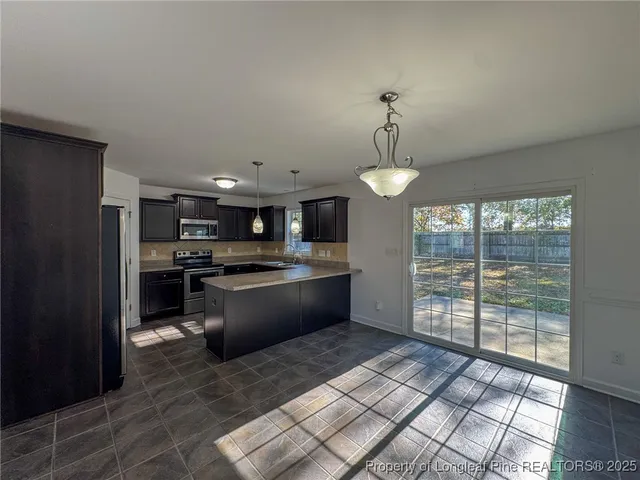 a large kitchen with kitchen island a large counter space a sink appliances and cabinets