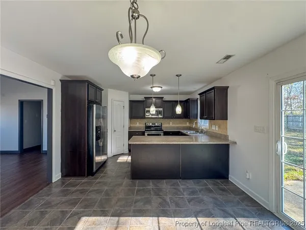 a large kitchen with stainless steel appliances granite countertop a refrigerator and a sink