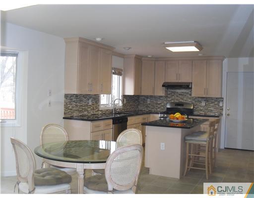 2 Mindy Road Edison, NJ 08820 - Photo 11 of 25 a kitchen with stainless steel appliances granite countertop a sink a stove a dining table and chairs
