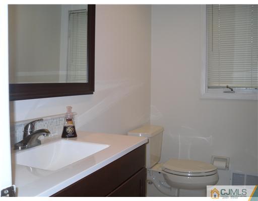 2 Mindy Road Edison, NJ 08820 - Photo 5 of 25 a bathroom with a sink a toilet and mirror