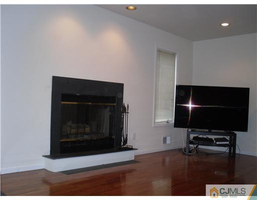 2 Mindy Road Edison, NJ 08820 - Photo 7 of 25 a living room with a fireplace and a flat screen tv