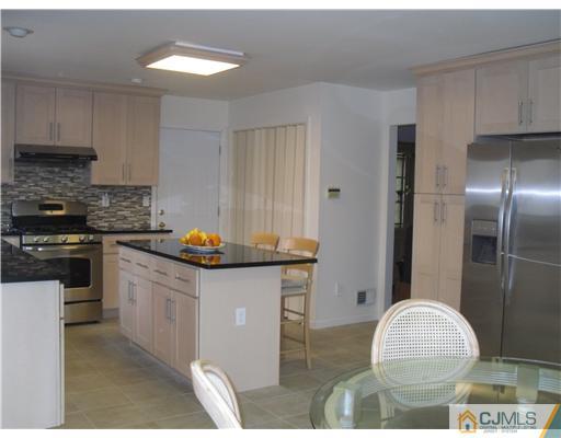 2 Mindy Road Edison, NJ 08820 - Photo 10 of 25 a kitchen with granite countertop a stove a sink and a refrigerator
