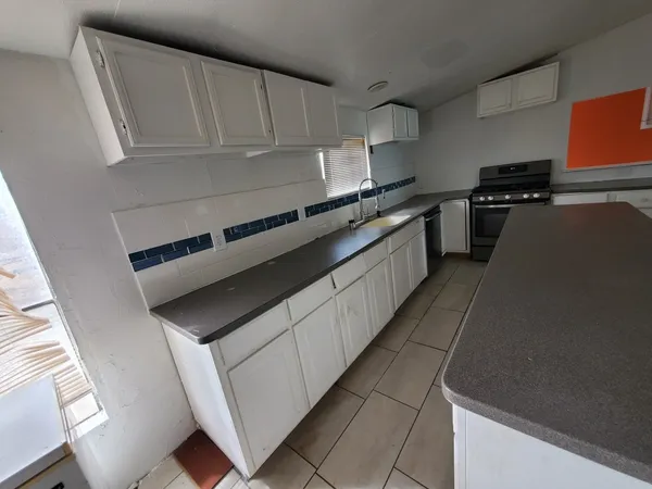 a kitchen with stainless steel appliances a sink stove and cabinets