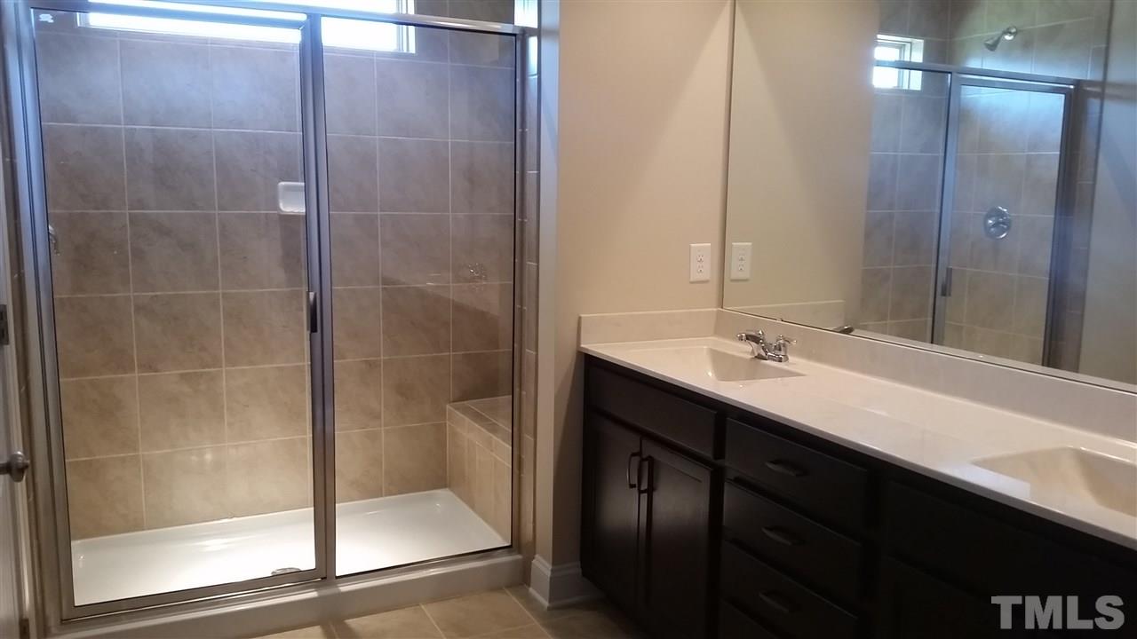 148 Token House Road Durham, NC 27703 - Photo 9 of 16 double sinks, recessed lights, tile shower with sink and nice lighting from window