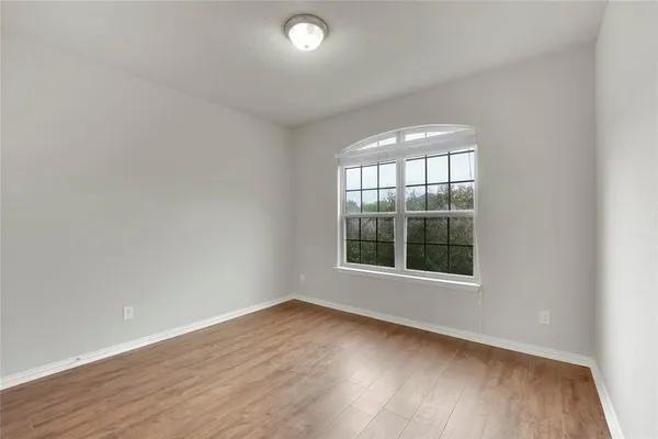 an empty room with wooden floor and a window