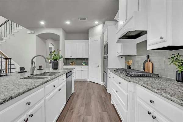 a kitchen with stainless steel appliances granite countertop a sink stove and cabinets
