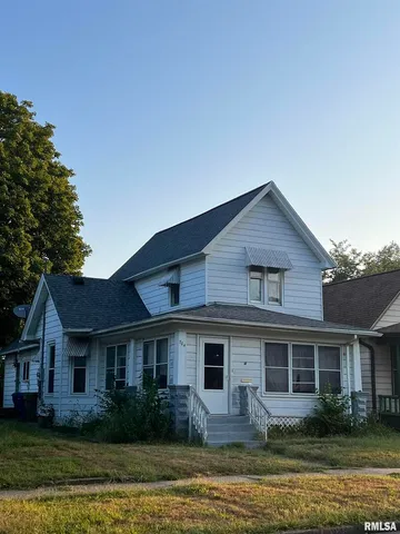 a front view of a house with a yard and potted plants