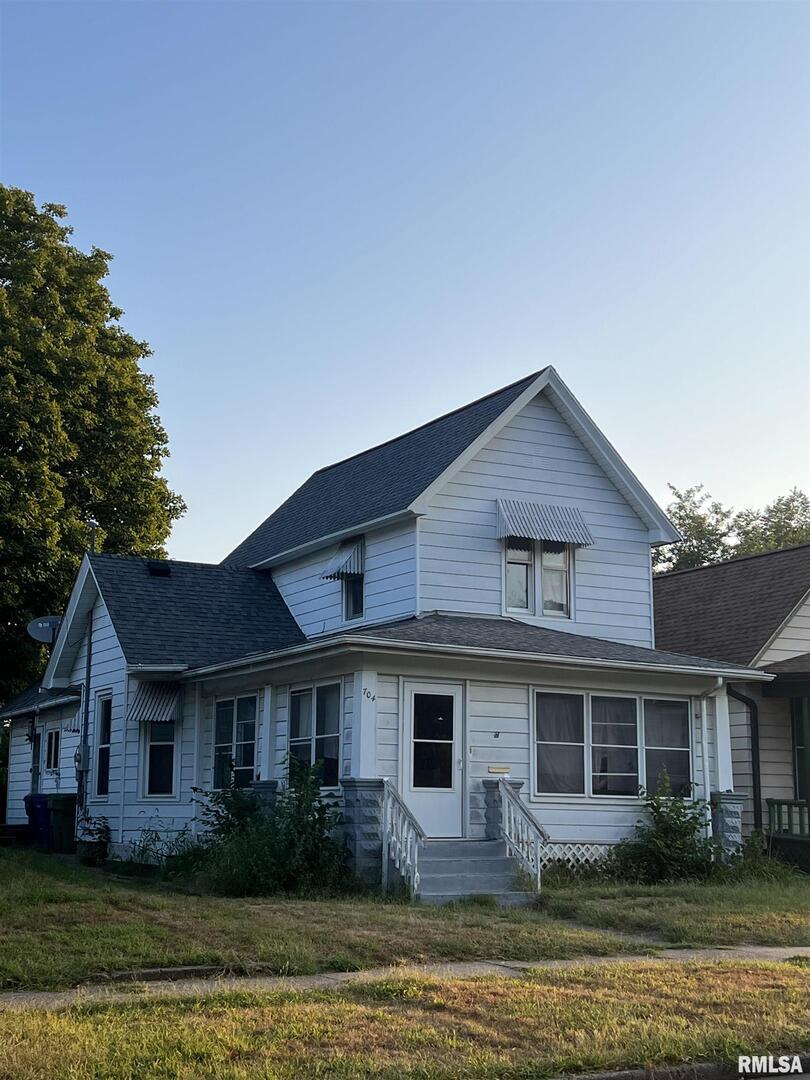 a front view of a house with a yard and potted plants