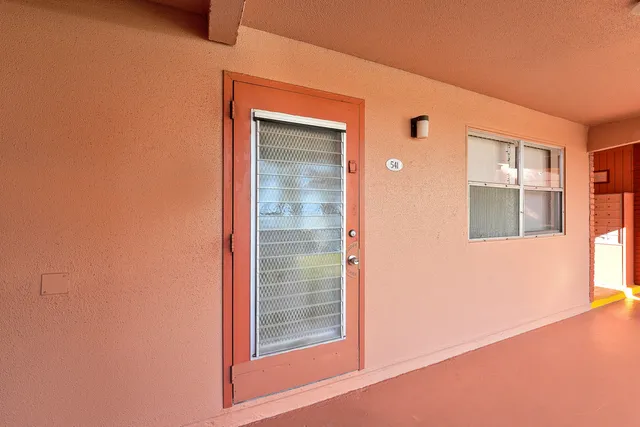 a view of a house with a big yard and potted plants