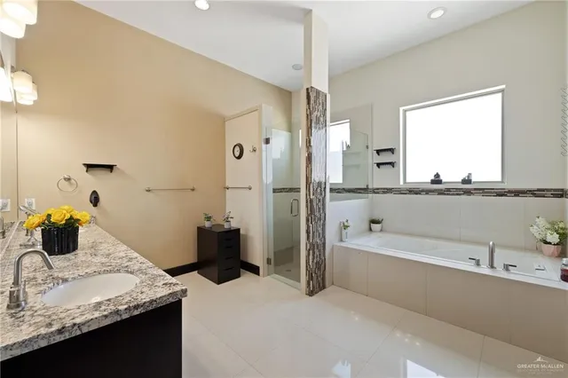 a bathroom with a granite countertop tub sink and mirror
