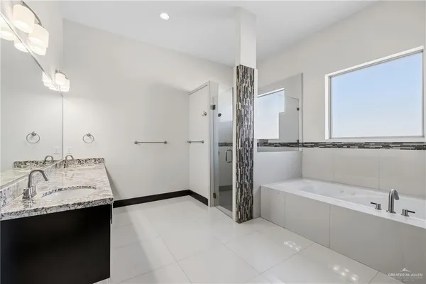 a bathroom with a tub sink shower and mirror