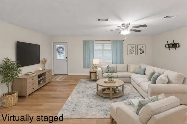 a view of empty room with wooden floor and fan