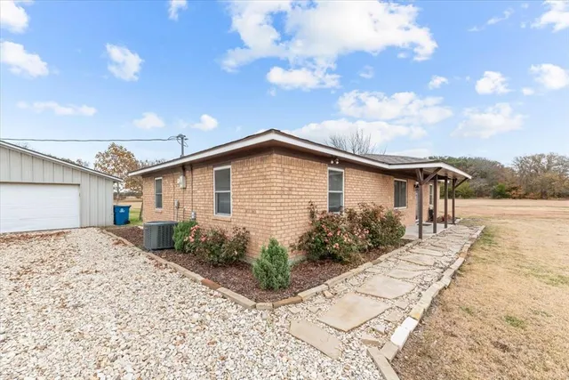 a front view of house along with pathway and wooden fence