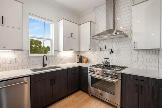 a kitchen with stainless steel appliances granite countertop a refrigerator and a stove top oven