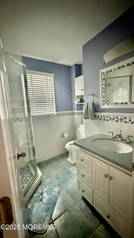 a bathroom with a granite countertop sink a mirror and a toilet