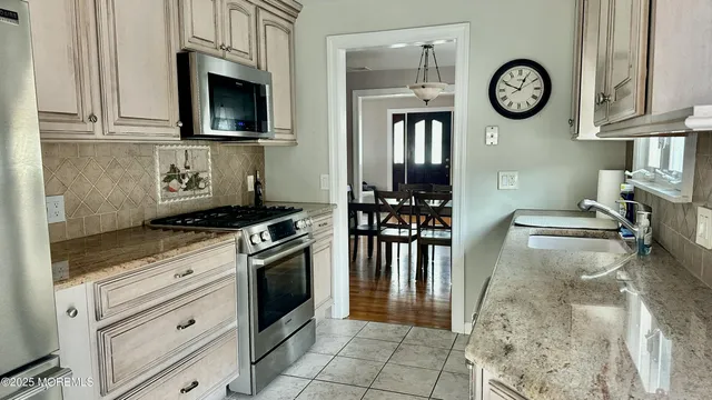 a kitchen with stainless steel appliances granite countertop a stove and a refrigerator with cabinets