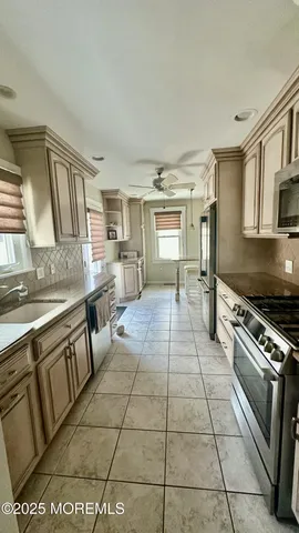 a kitchen with stainless steel appliances granite countertop a stove top oven a sink a counter space and cabinets
