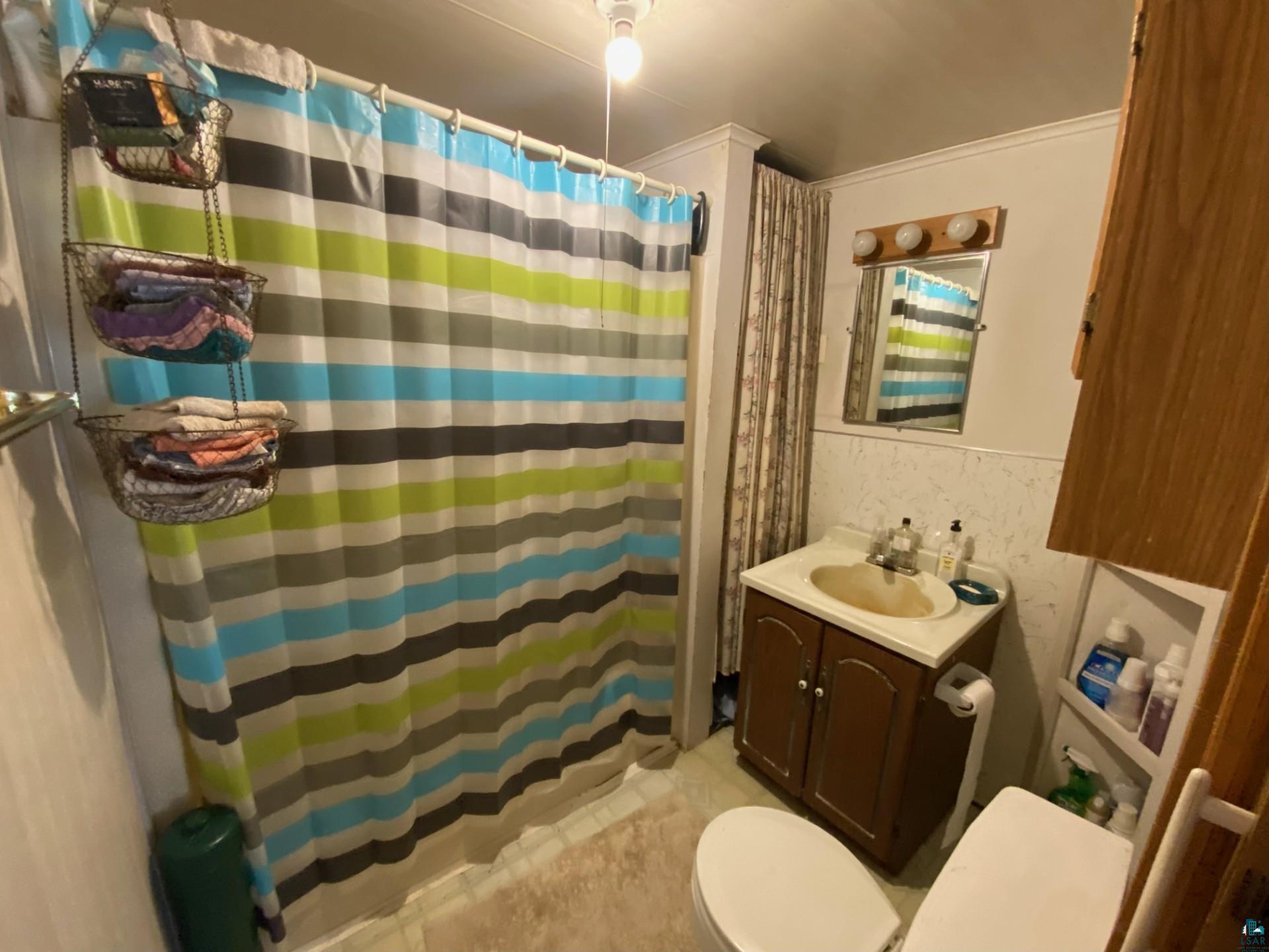 W6402 Old Bass Lake Road Minong, WI 54859 - Photo 12 of 18 Bathroom featuring tile patterned floors, toilet, and vanity