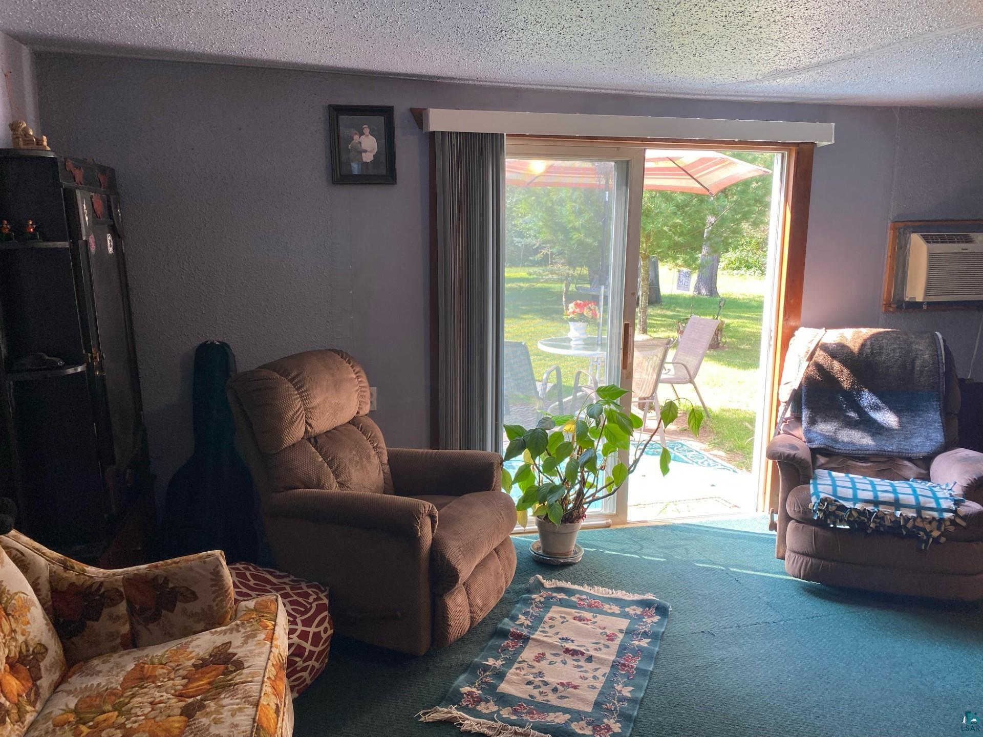 W6402 Old Bass Lake Road Minong, WI 54859 - Photo 8 of 18 Sitting room with carpet, a textured ceiling, and cooling unit