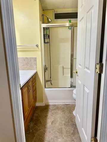 a bathroom with a tub shower and a sink