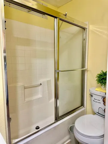 a bathroom with a toilet and a shower