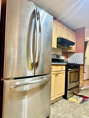 a kitchen with stainless steel appliances granite countertop a stove a microwave and a refrigerator