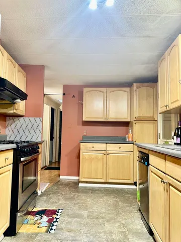a kitchen with stainless steel appliances granite countertop a stove sink and cabinets