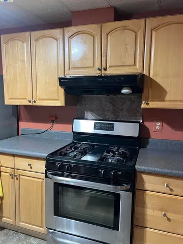 a stove top oven sitting inside of a kitchen