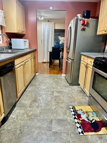 a kitchen with stainless steel appliances granite countertop a refrigerator and a sink