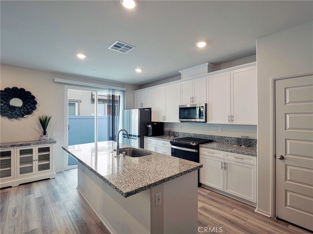40336 Birchfield Drive Temecula, CA 92591 - Photo 14 of 39 a kitchen with stainless steel appliances granite countertop a kitchen island hardwood floor sink and stove