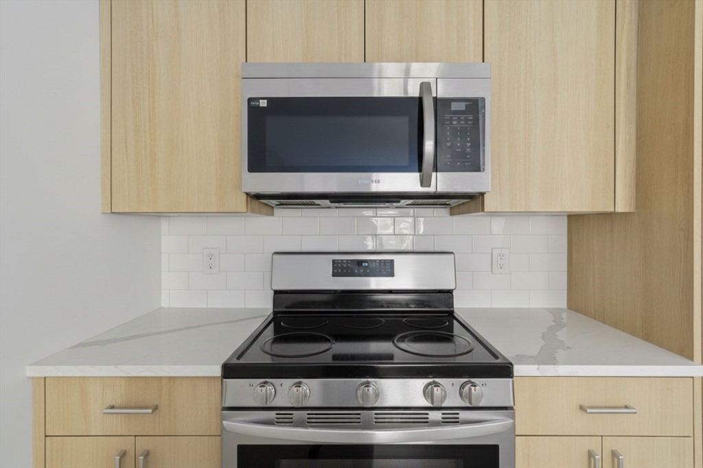 1035 Commonwealth Avenue, Unit 504 Boston, MA 02215 - Photo 2 of 18 a kitchen with microwave stove and cabinets