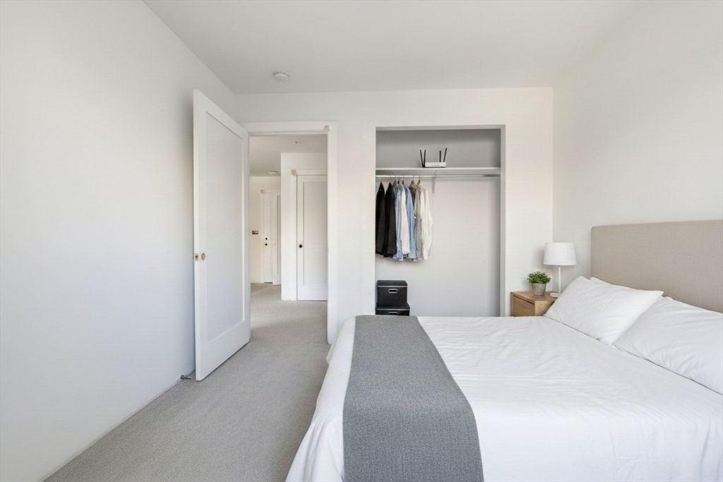 1035 Commonwealth Avenue, Unit 504 Boston, MA 02215 - Photo 8 of 18 a bedroom with a bed and a refrigerator