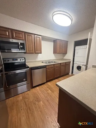 a kitchen with stainless steel appliances granite countertop a stove a sink and a microwave