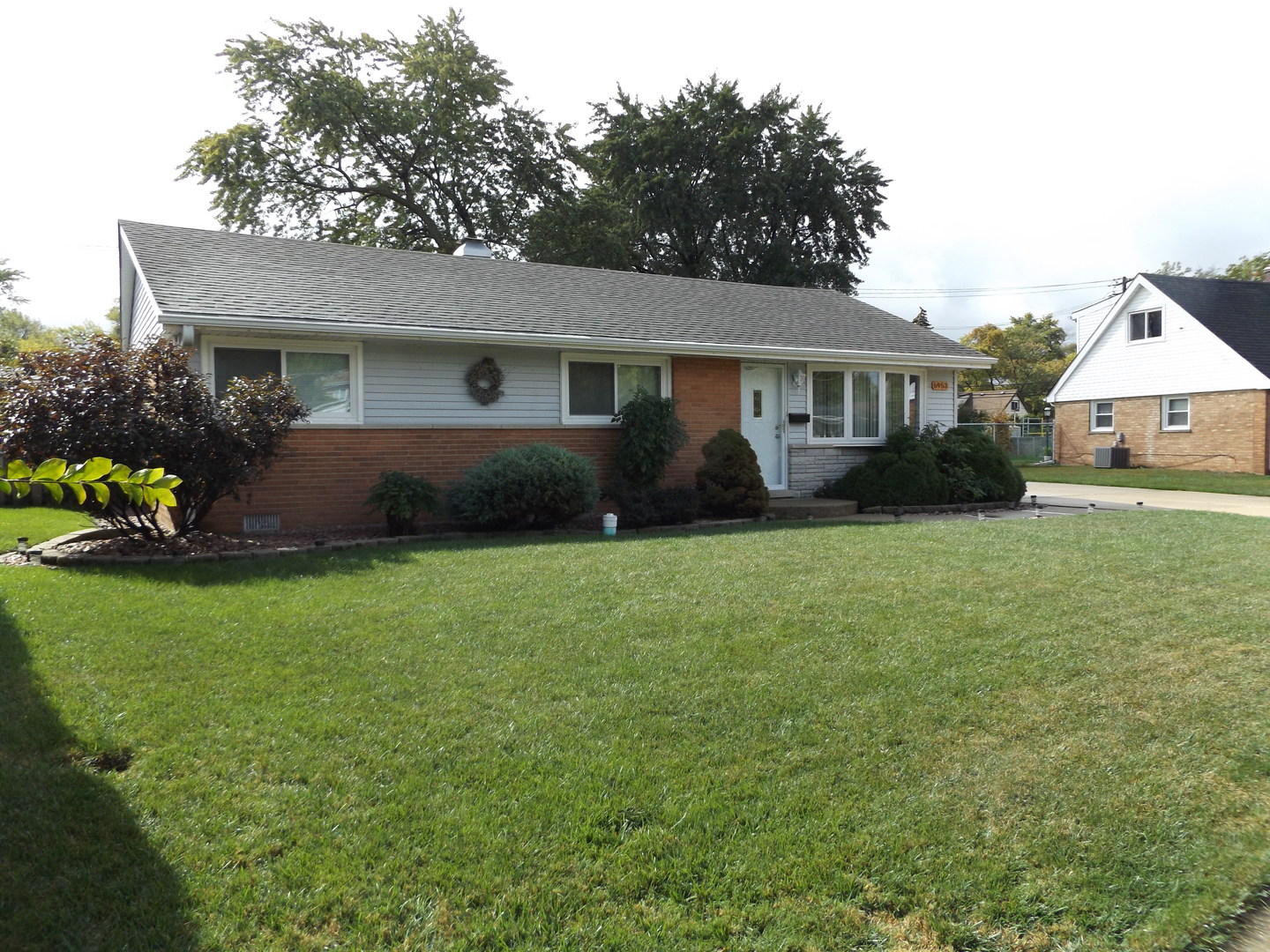 6953 Olympic Drive Bridgeview, IL 60455 - Photo 2 of 33 a front view of a house with a garden