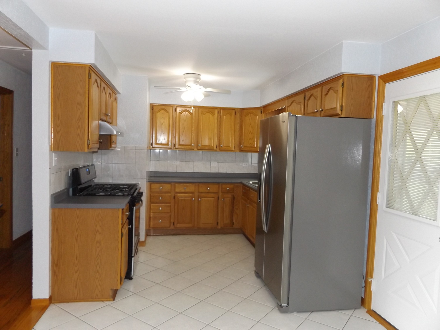 6953 Olympic Drive Bridgeview, IL 60455 - Photo 18 of 33 a kitchen with stainless steel appliances granite countertop a refrigerator and a stove