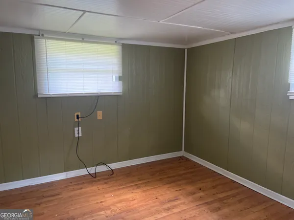 a view of room with window and wooden floor