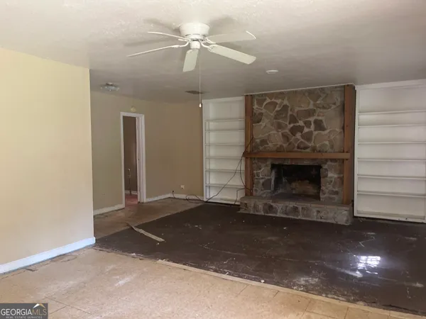 an empty room with a fireplace and fan