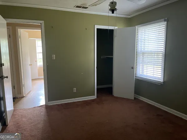 an empty room that has a window and wooden floor