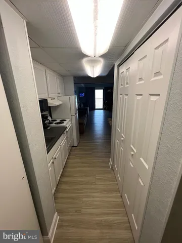 a view of a hallway with wooden floors and stairs