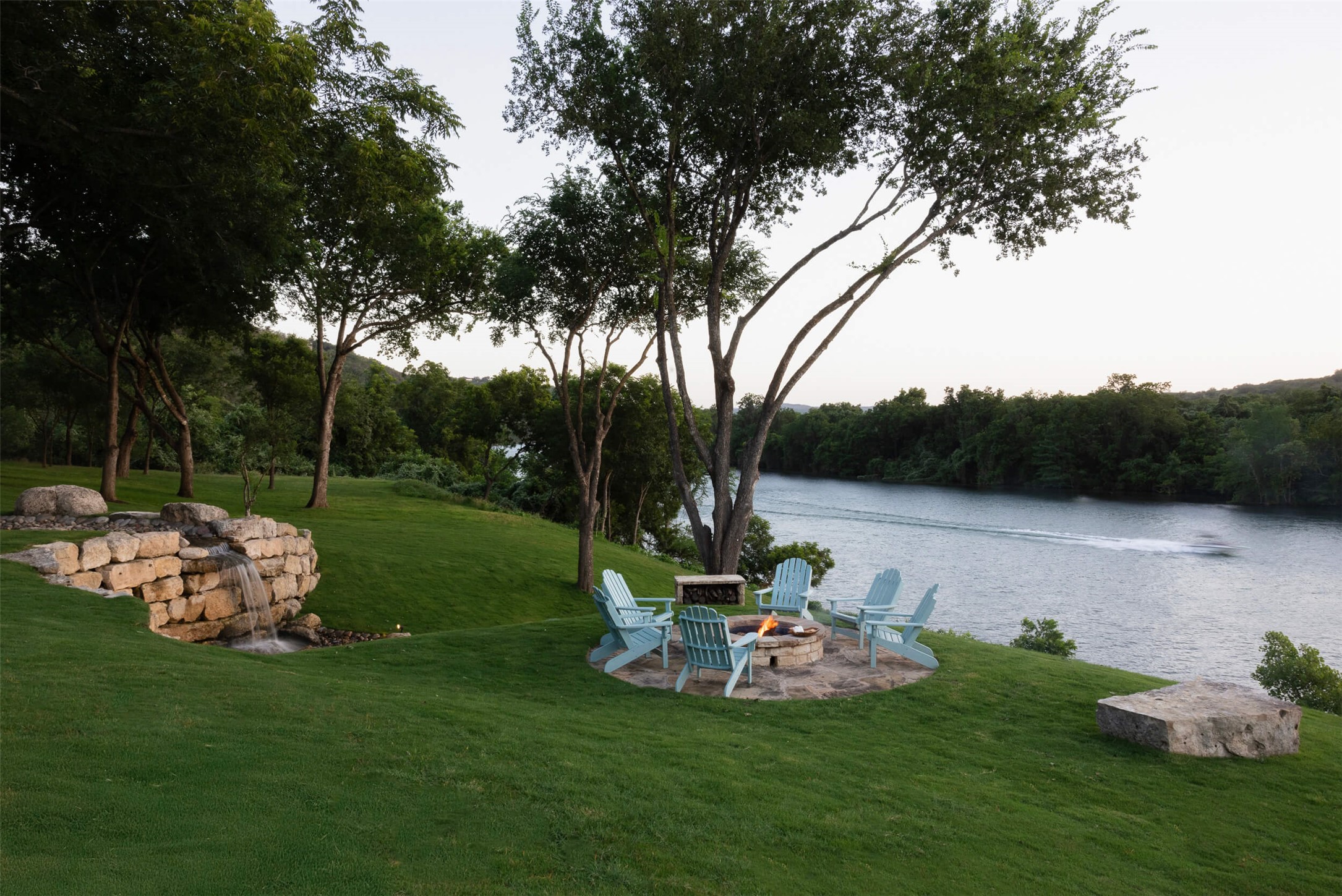 15016 Flat Top Ranch Road Austin, TX 78732 - Photo 8 of 40 View of grassy yard featuring a patio area, a water view, and a fire pit