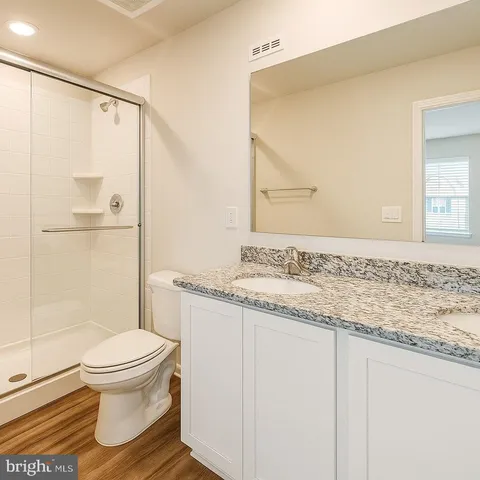 a bathroom with a granite countertop sink toilet and shower