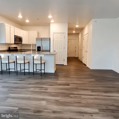 a view of kitchen with kitchen island white cabinets and stainless steel appliances