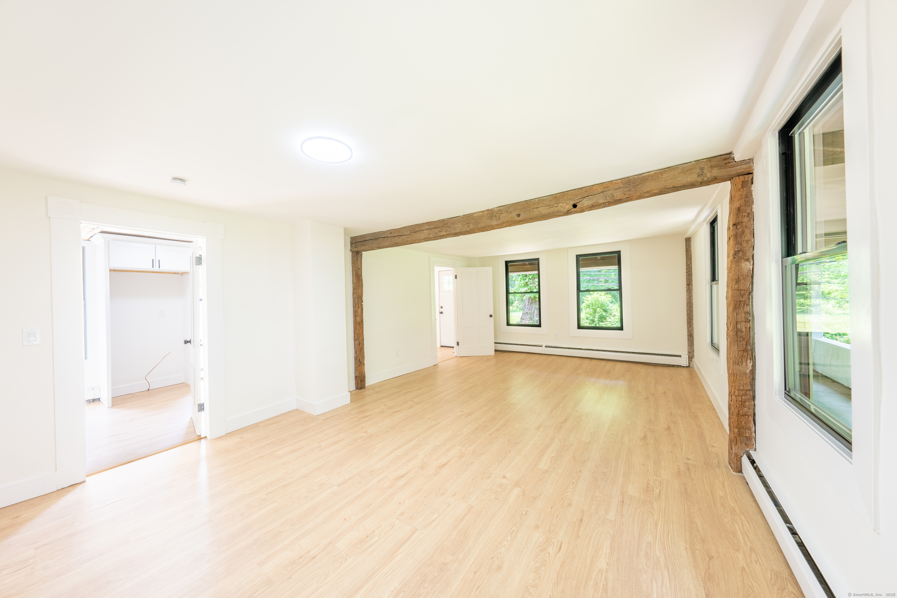 219 Redding Road Redding, CT 06896 - Photo 13 of 27 a view of an empty room with wooden floor and a window