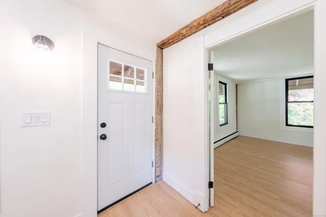 a view of an empty room with closet and a window