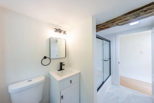 a bathroom with a toilet a sink and mirror