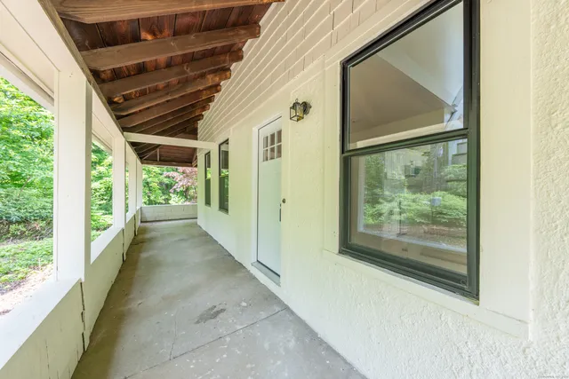 a view of a porch with wooden floor and doors