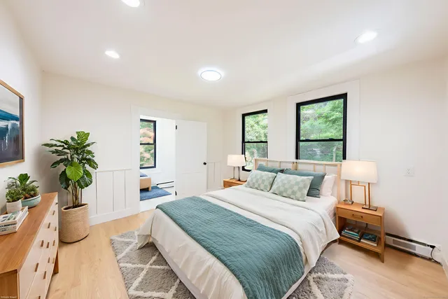 a bedroom with a bed and a potted plant