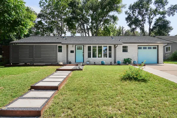 a view of a house with yard and chairs